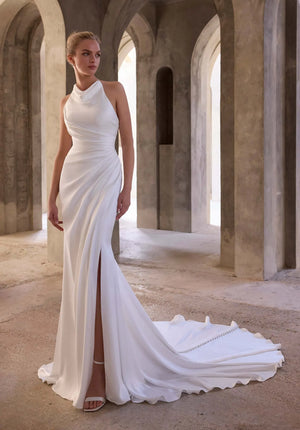 Modern sheath wedding dress with high halter neckline, side slit, and sleek draped fabric train.